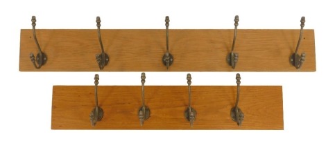 Two oak backed coat racks, comprising a five hook rack, 105cm long, and a four hook rack, 78cm long. (2)