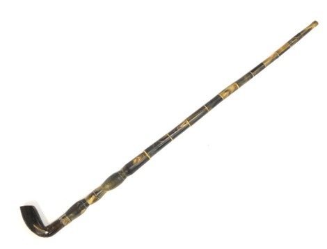 A carved horn walking cane, with a shaped handle and brass collar, 95cm long. (AF)