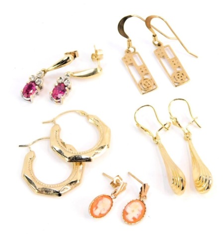 A group of 9ct gold and other earrings, comprising a pair of yellow metal hoops, stamped 375, a pair of drop earrings, yellow metal, stamped 375, a pair of gold plated rose design earrings, a pair of 9ct gold cameo set earrings, and a pair of paste stone 