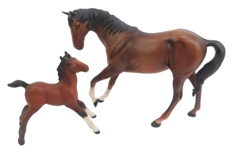 Two Beswick matt brown figures of horses, comprising a prancing horse, 20cm high, and a foal, 12cm high. (2)