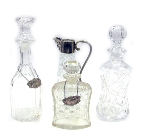 Four items of 20thC glassware, comprising a Victorian cut glass decanter and stopper, two further cut glass decanters and stoppers, with silver decanter labels for Brandy and Whisky, 21cm, 27cm and 29cm high, and a moulded glass claret jug, with plated mo