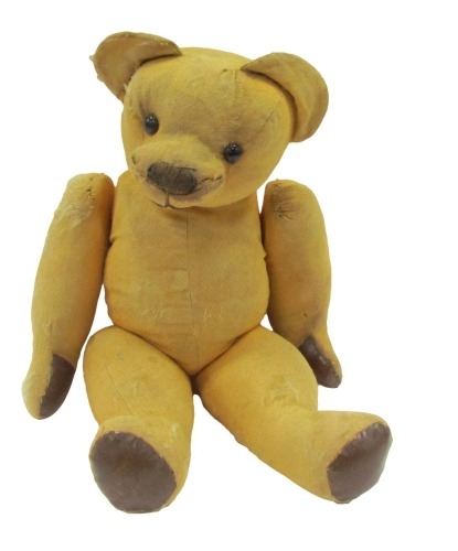 A plush blonde jointed Teddy bear, with leather pad paws and feet, and glass eyes, 60cm high. (AF)