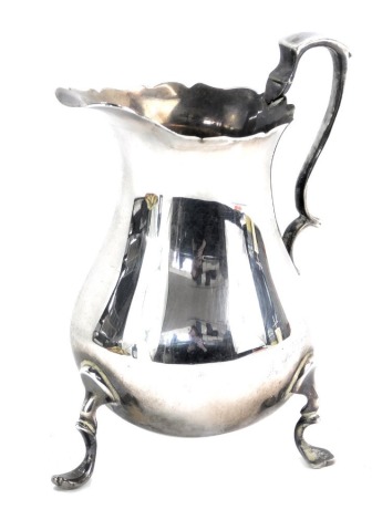 A George V silver cream jug, with a shaped rim, double scroll handle, raised on three scroll feet, Sheffield 1928, 2.82oz.