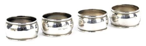 Four matched silver napkin rings, each with a moulded border, of plain design, with rubbed hallmarks, Edward VII and later, 1.28oz. (4)