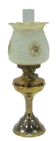 A 20thC oil lamp, converted to electricity, with a chimney, and a white and cream glass shade, with painted and transfer detail of flowers, 58cm high.