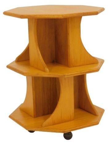 An oak revolving two tier octagonal bookcase, with various recesses, on castors, 69cm high, 53cm wide.