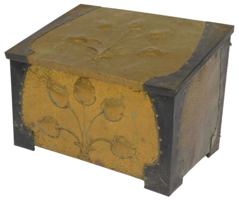 An Art Nouveau hammered brass coal box, the sloping lid with flower head decoration with cast metal end mounts, with further floral decoration to front, 57cm wide.