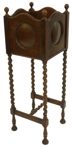 A 1920's oak jardiniere stand, the cubed top with roundel to each panel, raised on spiral turned legs with support, 90cm high.