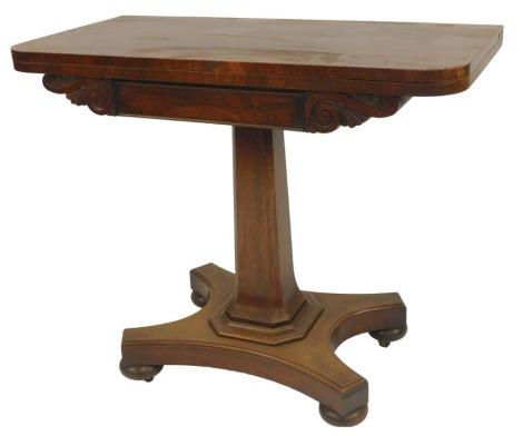 A Victorian rosewood card table, the foldover top with green baize interior, scroll carved apron on a tapering column, on quatrefoil base, raised on compressed bun feet with castors, 75.5cm high, 87cm wide, 45cm deep.