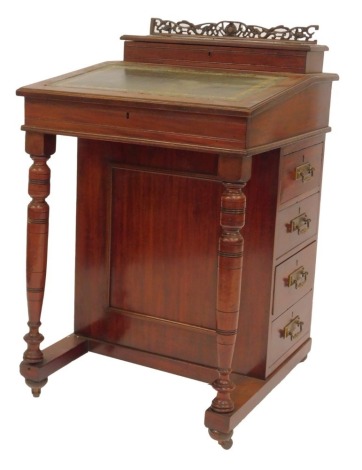 A late Victorian mahogany Davenport, the top with a pierced frieze above a hinged recess for pens, the sloping fall inset with a green tooled leather panel enclosing recesses and drawer, the base with four drawers to one side and dummy drawers to the othe