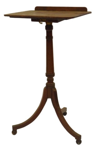 A Regency mahogany reading or music stand, the top with a rounded edge with a raised back on a cylindrical carved column, on three out swept inlaid legs, raised on orb feet, 77.5cm high, 43cm wide, 35cm deep.