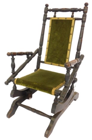 A 19thC American ebonised child's rocking chair, with green draylon seat and back.