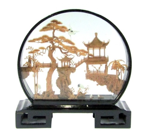 A Fujian cork picture, depicting a pagoda, storks, further buildings, etc, within flowering trees, in an ebonised frame, 22.5cm high, boxed.