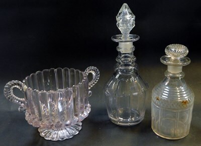 A group of glassware, comprising a Georgian cut glass decanter and stopper, 27cm high, a further decanter and stopper, 19cm high, and a late 19thC moulded glass two handled sugar bowl, 13cm high.