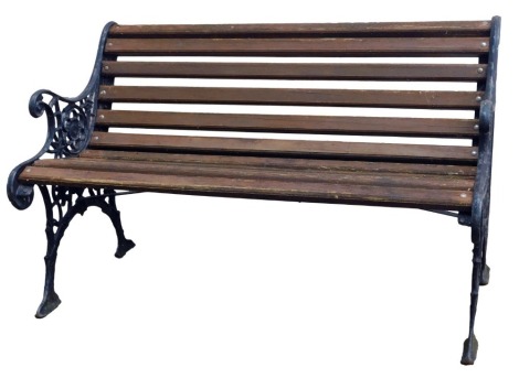 A 20thC garden bench, with wooden slats, on shaped cast ends painted in black, 75cm high, 121cm wide.