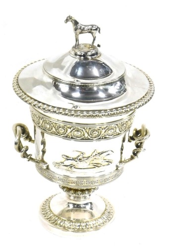 A George III Garrard silver two handled horse racing trophy and cover, the lid with a horse finial, the base with foliate and geometric bands, serpent handles and cast with horses in relief opposing a vacant cartouche, engraved to base Garrard, Panton Str