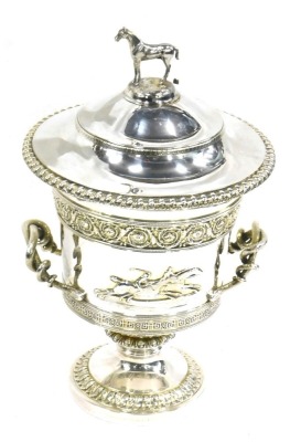 A George III Garrard silver two handled horse racing trophy and cover, the lid with a horse finial, the base with foliate and geometric bands, serpent handles and cast with horses in relief opposing a vacant cartouche, engraved to base Garrard, Panton Str