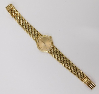 An Omega Deville 18ct gold ladies wristwatch, with a circular gold finish dial, and diamond set bezel and outer border, on four bar bracelet design, serial number 54282834, the dial 2.5cm diameter, 45.1g all in. - 2