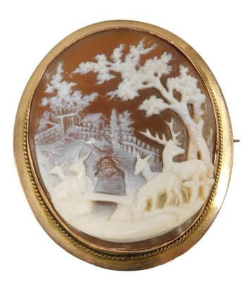 A 19thC shell cameo brooch, the cameo in raised relief depicting deer, bridge and trees, in a rope twist rub over border, on single pin back stamped 9ct, 5cm x 4.5cm, 13.1g all in.