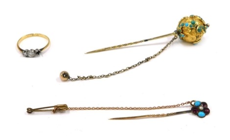 Three items of jewellery, comprising a Victorian orb stick pin, the orb top with heavy floral scroll design, set with turquoise, yellow metal unmarked, 7cm high, a garnet and turquoise set floral stick pen with safety chain, 4.5cm high, an 18ct gold and p