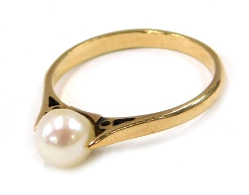 A cultured pearl dress ring, the central pearl tension set, with pierced design shoulders, yellow metal stamped 9ct, ring size M, 1.7g all in.