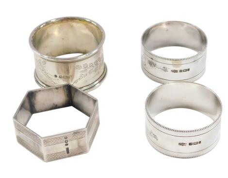 Four silver napkin rings, comprising a pair with beaded border bearing the initials FD, a hexagonal napkin rings, and a ribbed border napkin ring, 3.07oz. (4)