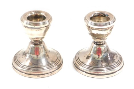 A pair of Elizabeth II silver dwarf candlesticks, each on weighted bases, with rubbed hallmarks, possibly Birmingham, B & Co, 5.73oz gross.