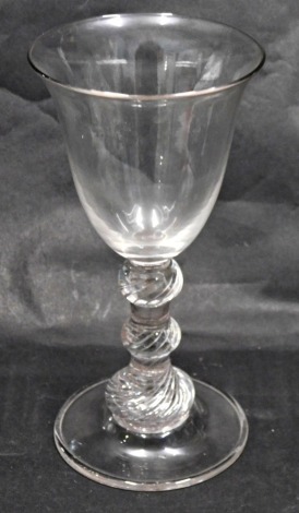 A late 18th/early 19thC wine glass, with a bell shaped bowl and triple air twist knopped stem, fold over foot, 21cm high.