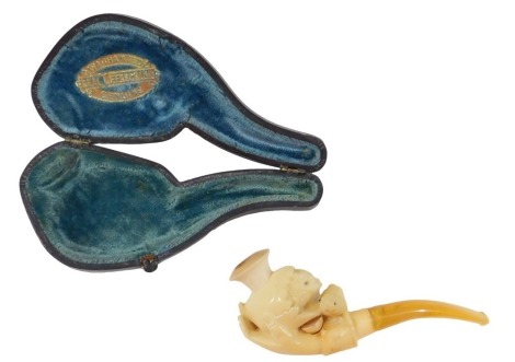 A Meerschaum pipe, the carved Meerschaum with chicks held in a hand, with an amber handle, in a fitted case, 13cm long. (AF)