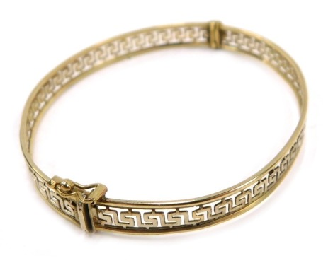 A hinged bangle, with Greek key pierced centre design, on white gold finish with a yellow metal border stamped Italy 375, 6.5cm diameter, 8.9g all in.