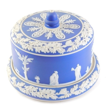 A Wedgwood style dark blue Jasperware cheese dome and cover, decorated with figures, acorns, oak leaves, etc., 20cm high.