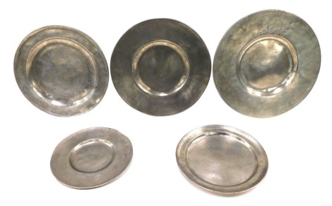 A collection of pewter plates, to include a broad rim example, engraved with a crest, indistinct touch marks, 36cm diameter, another similar example with a continental engraved crest of bearing date 1712. (5)