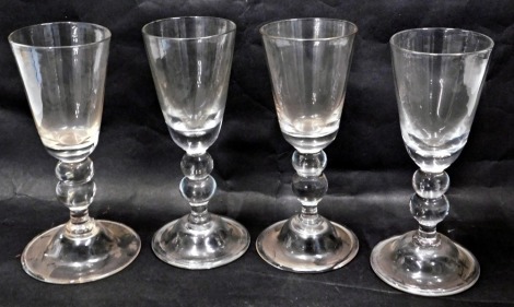 A set of four 20thC hand blown glasses, each with a fluted bowl, on double bulbous stem on circular foot, 23cm high. (4)