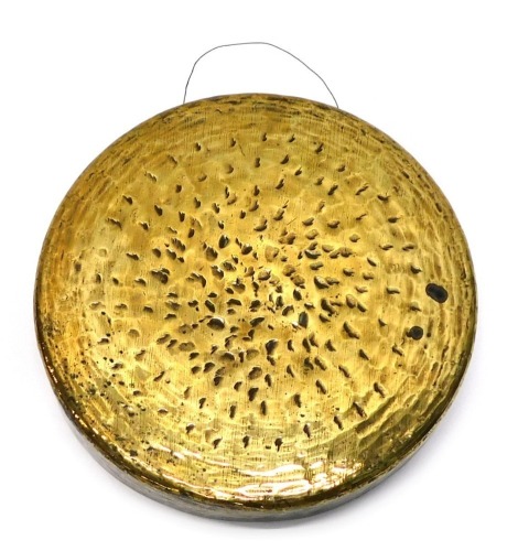 A polished bronze gong, 40cm diameter.