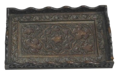 An Indian carved hardwood two handled tray, decorated with berries, leaves, etc., 54cm wide. (AF)