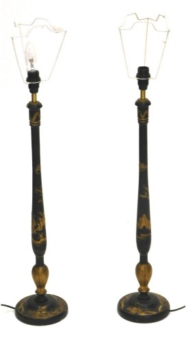 A pair of Japanned table lamps, each decorated in gilt with Oriental figures, landscapes, etc., on a black ground, 75cm high to top of fitting. WARNING! This lot contains untested or unsafe electrical items. It is supplied for scrap or re-conditioning on