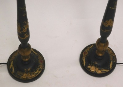 A pair of Japanned table lamps, each decorated in gilt with Oriental figures, landscapes, etc., on a black ground, 75cm high to top of fitting. WARNING! This lot contains untested or unsafe electrical items. It is supplied for scrap or re-conditioning on - 2