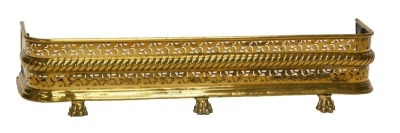 A late 19th/early 20thC brass fender, with a pierced border above a gadrooned band, on paw feet, 109cm wide.