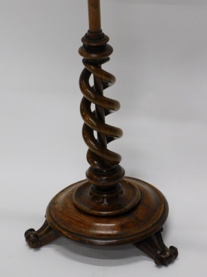 An early Victorian walnut pole screen, the associated rosewood banner inset with pleated fabric, on a part spirally turned column, circular moulded base and scroll feet, 145cm high. - 2