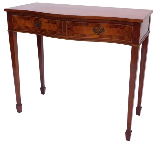 A yew serving table, the cross banded serpentine fronted top above two frieze drawers, on square tapering legs with spade feet, 86cm high, 99cm wide.