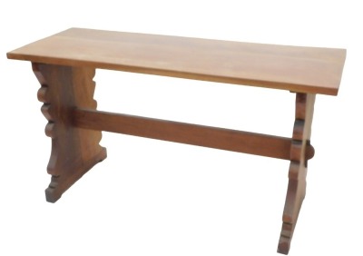 A walnut refectory style side table, with a rectangular planked top on shaped end supports, with stretcher, possibly Spanish, 74.5cm high, the top 138cm wide, 52cm deep.