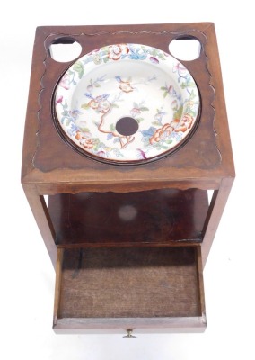 A George III mahogany washstand, the square top with a recess for a bowl and two further beaker recesses, above a second tier with drawer, on square section legs with concave stretcher, the recess now with associated ironstone bowl, 79cm high, 32cm wide. - 2