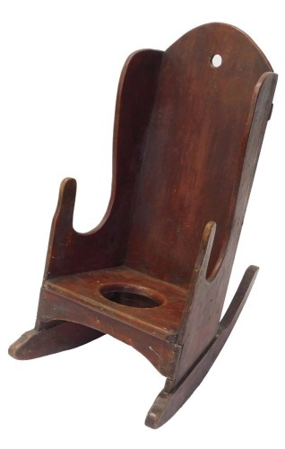 A 19thC country made child's red stained pine commode rocking chair, with shaped back.