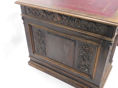 A Continental carved kneehole oak desk, the rectangular top with an ox blood red leatherette inset, with a moulded edge above arrangement of three frieze drawers and two panelled doors, on plinth, 83cm high, 153cm wide, 92cm deep. (AF) - 3