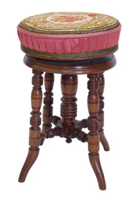 A late Victorian walnut adjustable piano stool, with a padded seat, on turned legs.