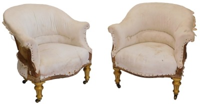 A pair of 19thC gilt tub shaped armchairs, upholstered in white ticking, on turned fluted legs with castors. (AF)