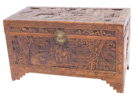 An Eastern carved camphor chest, decorated with figures, buildings, etc., on bracket feet, 100cm wide.