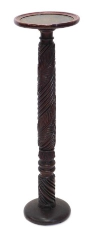 A mahogany plant stand or torchere, the circular dish top with green leatherette insert, on a leaf carved turned column and domed foot, 108cm high, 31cm wide.