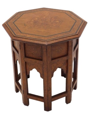 An Indian hardwood and marquetry occasional table, the octagonal top on a folding stand, decorated with arches, etc., 48cm high, 55cm wide.