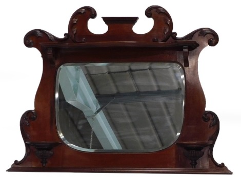 An early 19thC mahogany overmantel mirror, with a shaped crest above a shelf and an oval bevel plate, with further demi-lune shelves, on a plinth, 85cm high, 112cm wide.